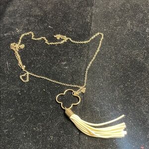 Gold Tone Necklace Featuring A Clover Charm and Cream Tassel Pendant.